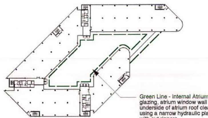 An architectural floor plan showing a commercial office layout with a central atrium highlighted by green lines and structural columns.