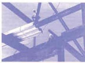 A low-resolution photograph showing steel beams and a worker on a construction site, likely part of the structural framework for the proposed development.