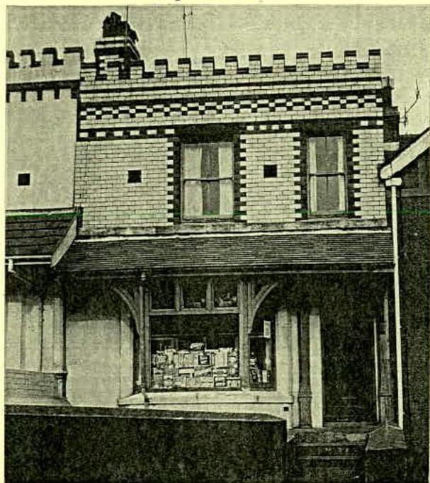 A vintage black and white photograph showing the front elevation of a two-story commercial building with distinctive decorative brickwork and a shop front.
