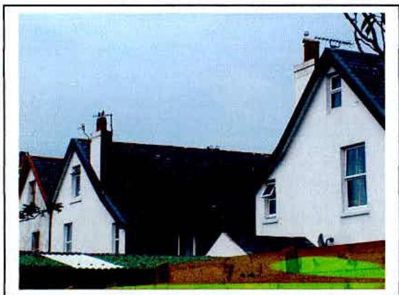 A photograph showing the exterior of a row of white semi-detached houses with a garden wall in the foreground.