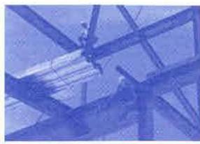 A blue-tinted photograph showing exposed structural beams and framing, likely depicting interior construction work or renovation details.