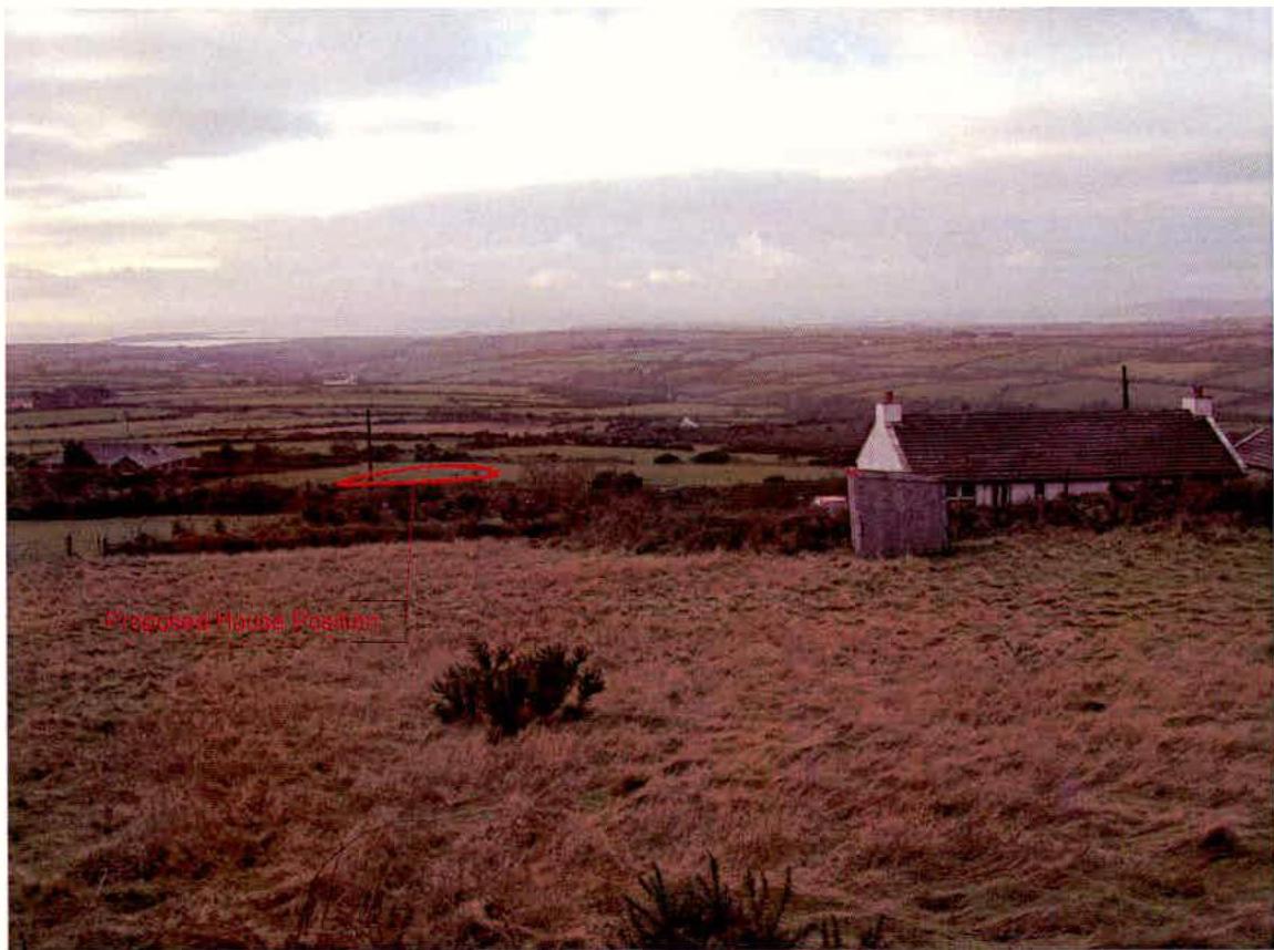 A landscape photograph showing a rural field with a white building on the right and a distant coastal view, featuring red annotations overlaid on the scene.