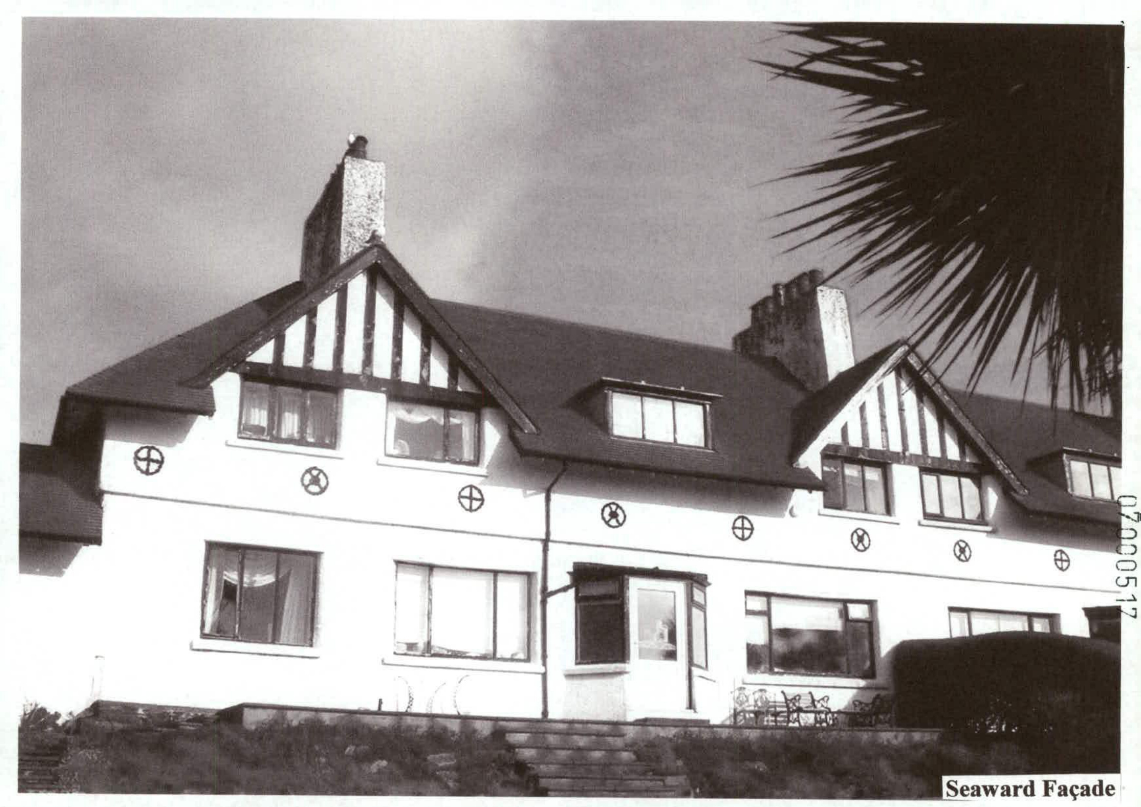 A black and white photograph showing the seaward façade of a large, two-storey detached house with Tudor-style gables.