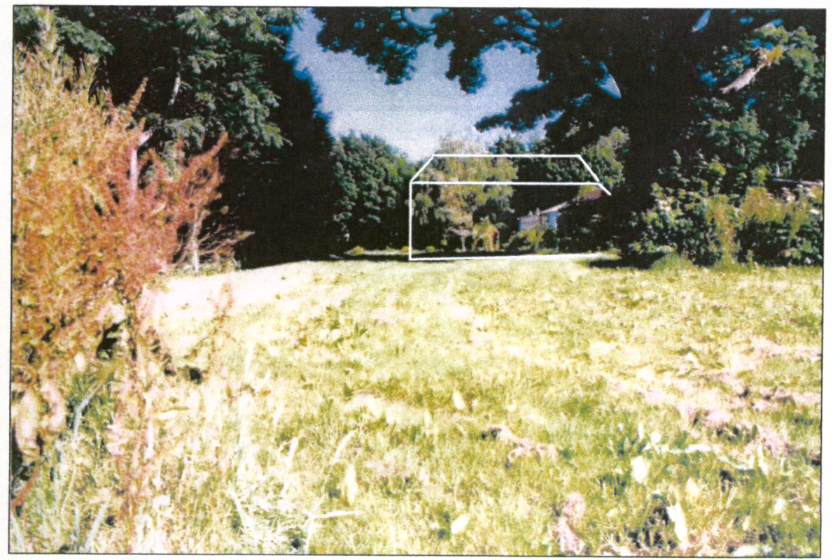 A site photograph showing a grassy field with a white outline of a proposed house superimposed to indicate the building footprint.