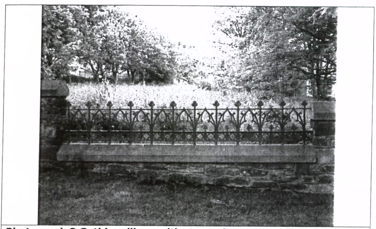 A black and white photograph showing a stone boundary wall topped with a decorative metal railing and gate posts, with trees and a grassy area in the background.