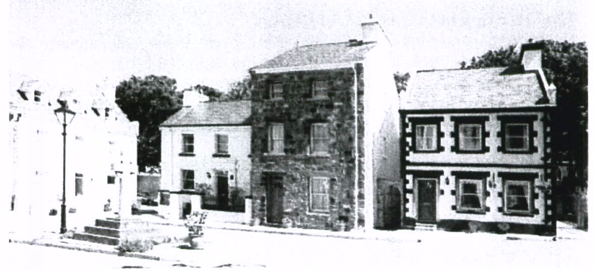 A grainy black and white photograph showing a row of traditional stone and whitewashed buildings along a street.