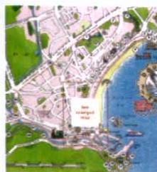A site location map showing a coastal area with a beach and buildings. A white box indicates the specific site location near the waterfront.