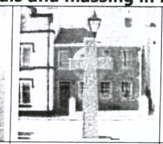 A low-resolution black and white image depicting a street scene with a two-story building and a lamp post in the foreground.