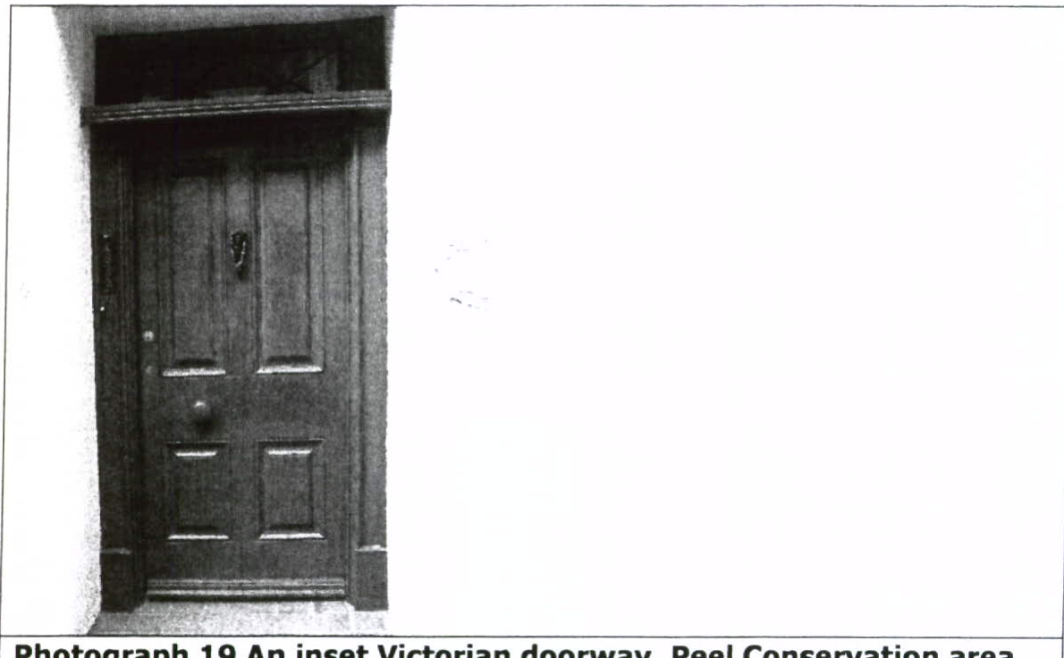 A black and white photograph showing a traditional inset Victorian doorway with a wooden door and knocker, captioned as being in the Peel Conservation area.