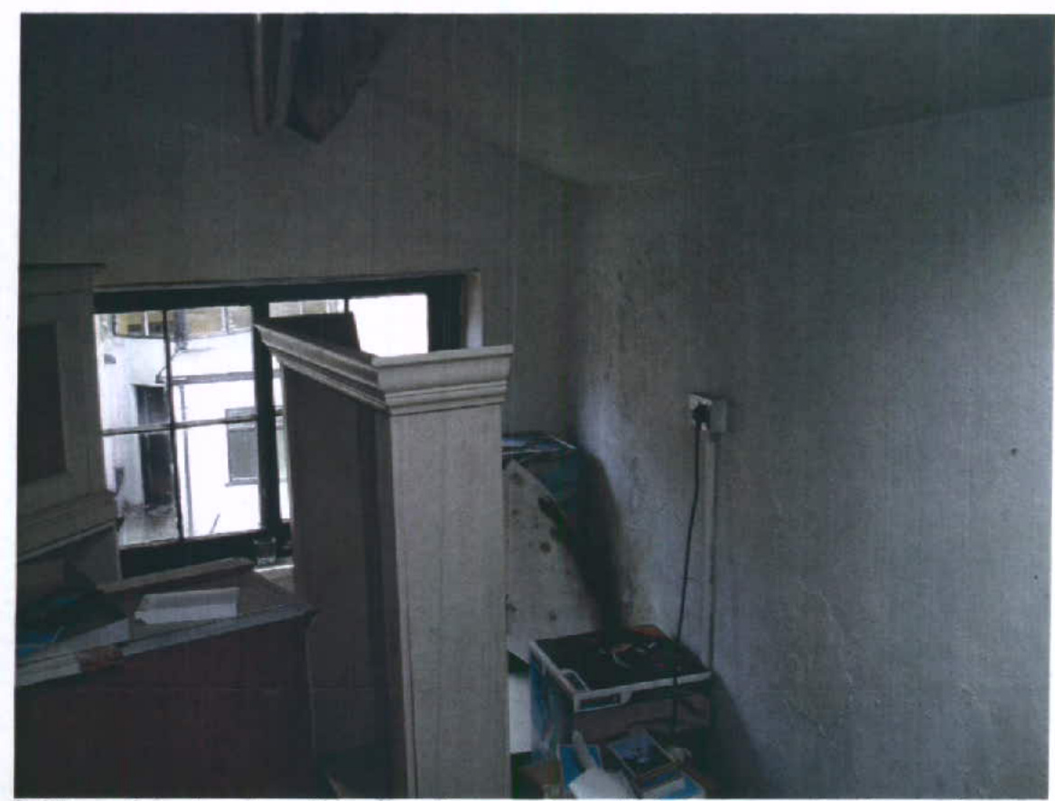 Interior photograph showing a room with unfinished walls and a window, likely part of the outbuilding conversion.