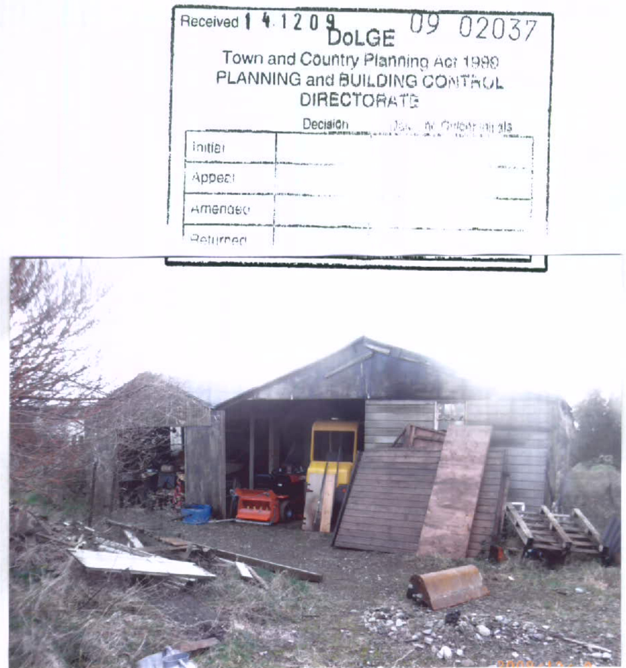 A planning document page featuring a received stamp at the top and a photograph of an existing wooden barn or shed with farm machinery inside.