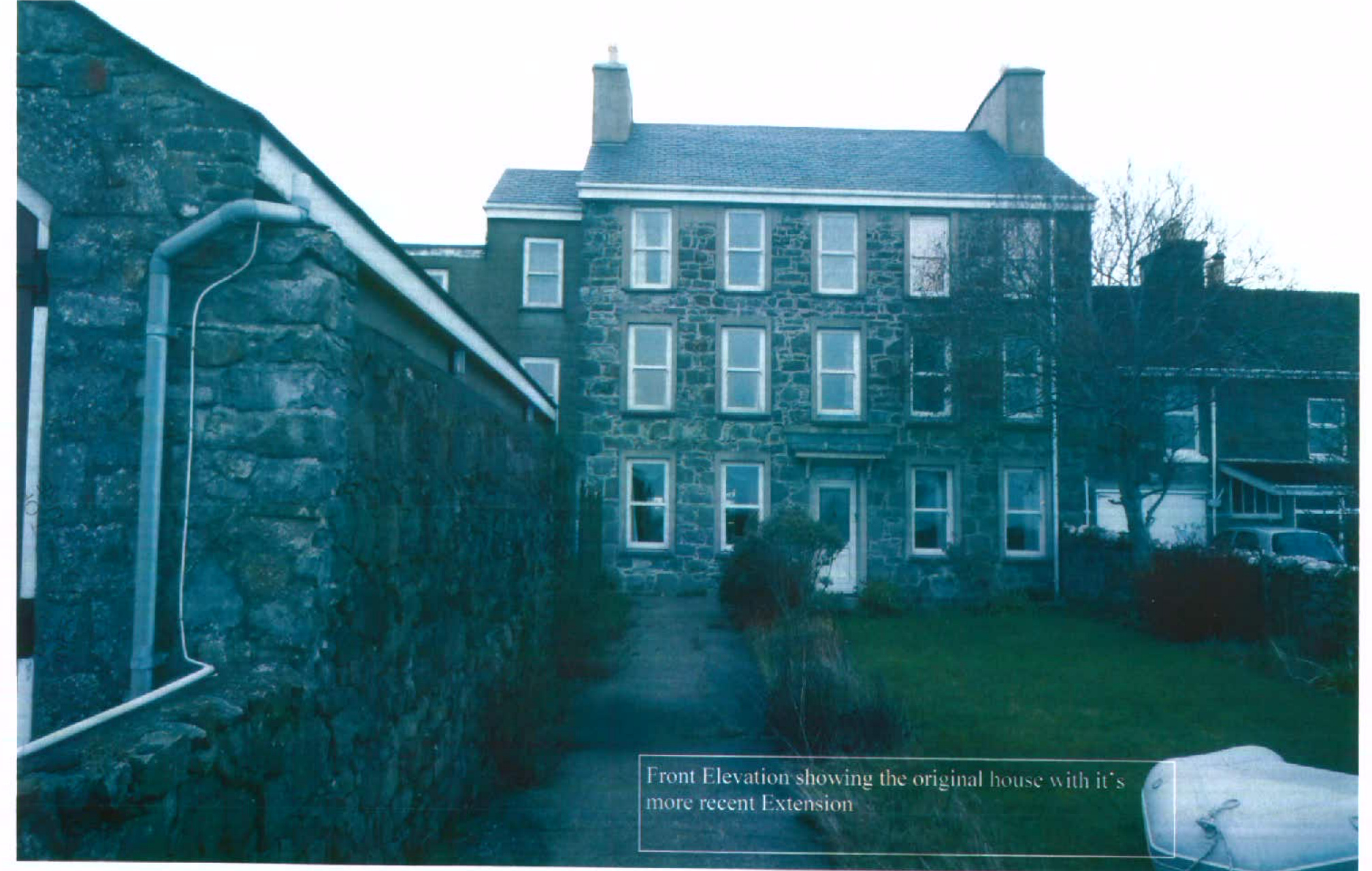 A photograph of a stone house showing the front elevation, with a caption indicating an original house and a recent extension.