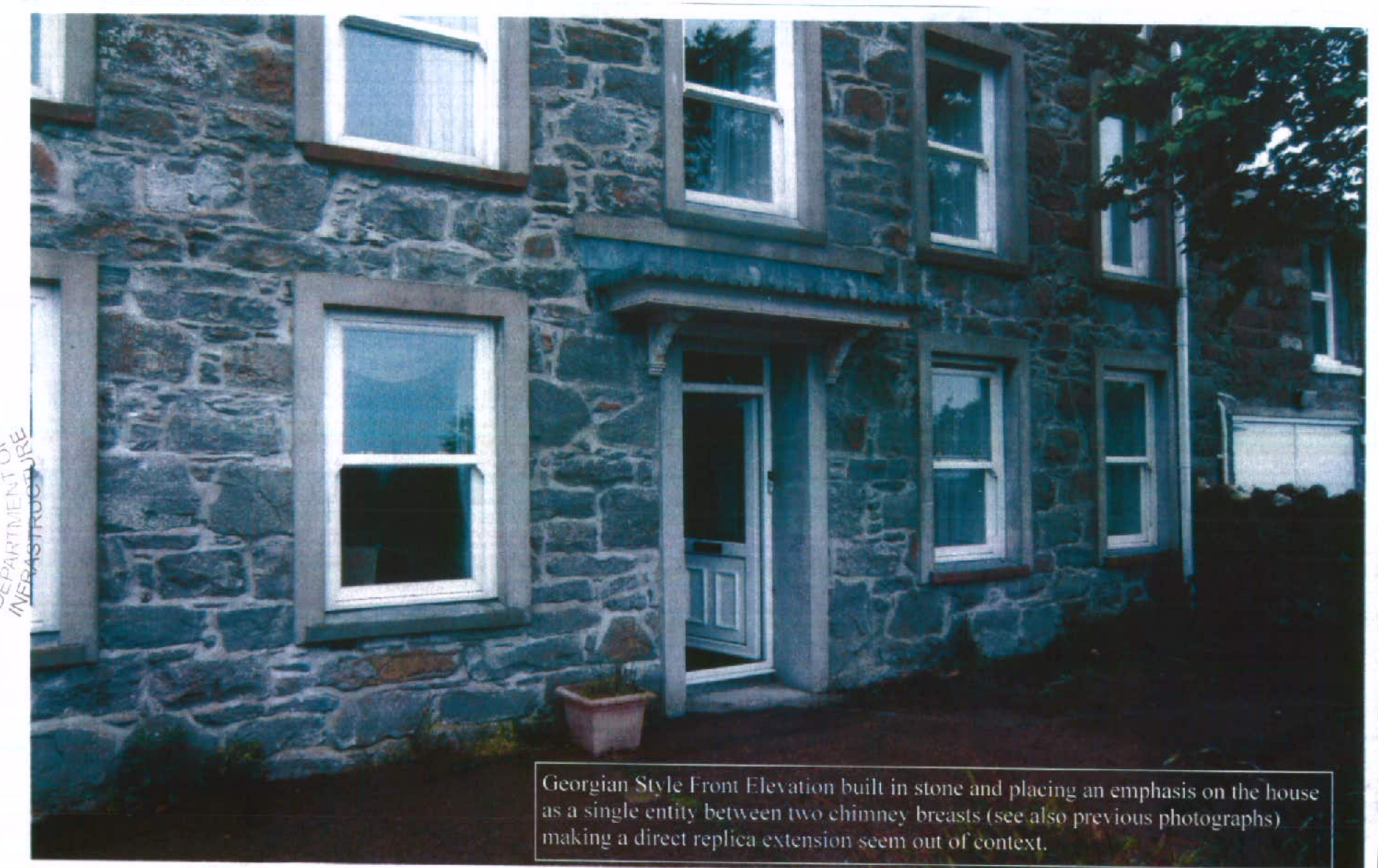 A photograph showing the stone front elevation of a Georgian-style house with white sash windows and a central door, accompanied by text describing the architectural context.
