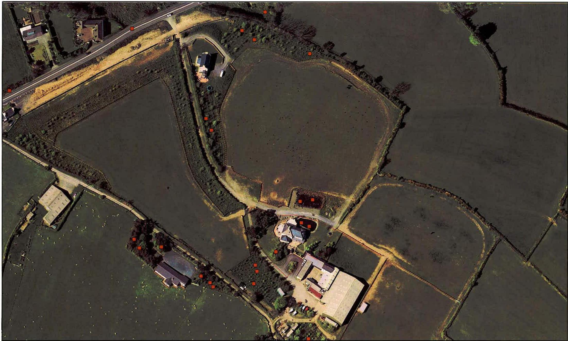 An aerial view of a rural property showing fields, hedgerows, and buildings with red marker points overlaid.