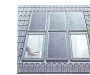 A close-up photograph of a grey tiled roof featuring a dormer window structure with a grid of panes.