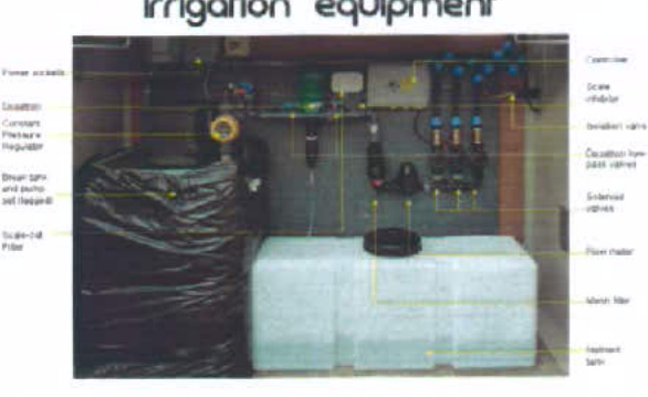 A labeled photograph of an irrigation system setup featuring tanks, filters, and valves with yellow annotation lines pointing to components.