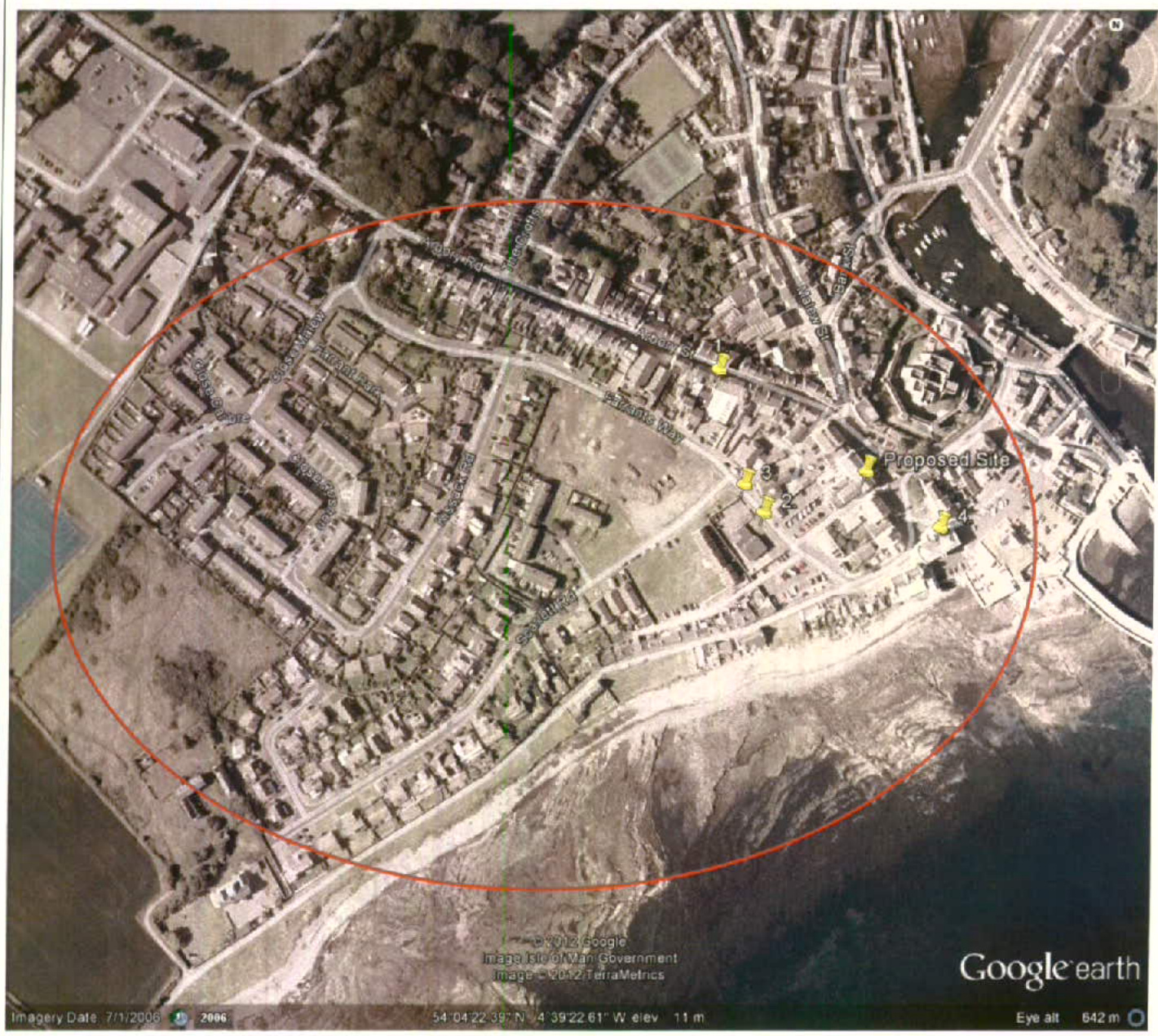 An aerial Google Earth view showing a coastal town area with a red circle highlighting a specific zone and yellow pins marking a proposed site location.