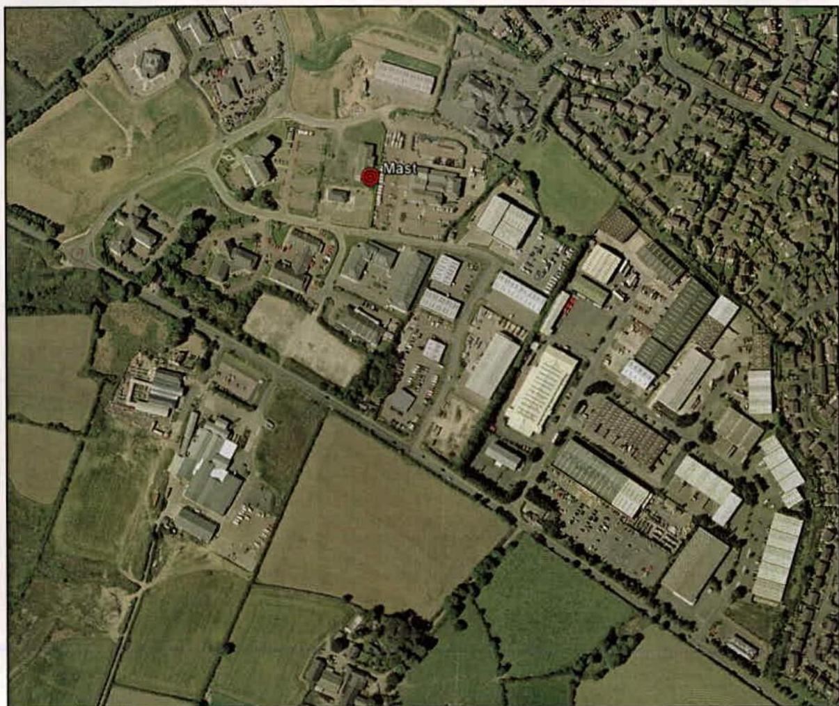 An aerial view showing an industrial estate with a red dot marking the proposed mast location.