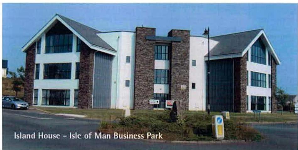 A photograph of a modern commercial building with white and stone cladding, identified as Island House at the Isle of Man Business Park, with a car parked in the foreground.