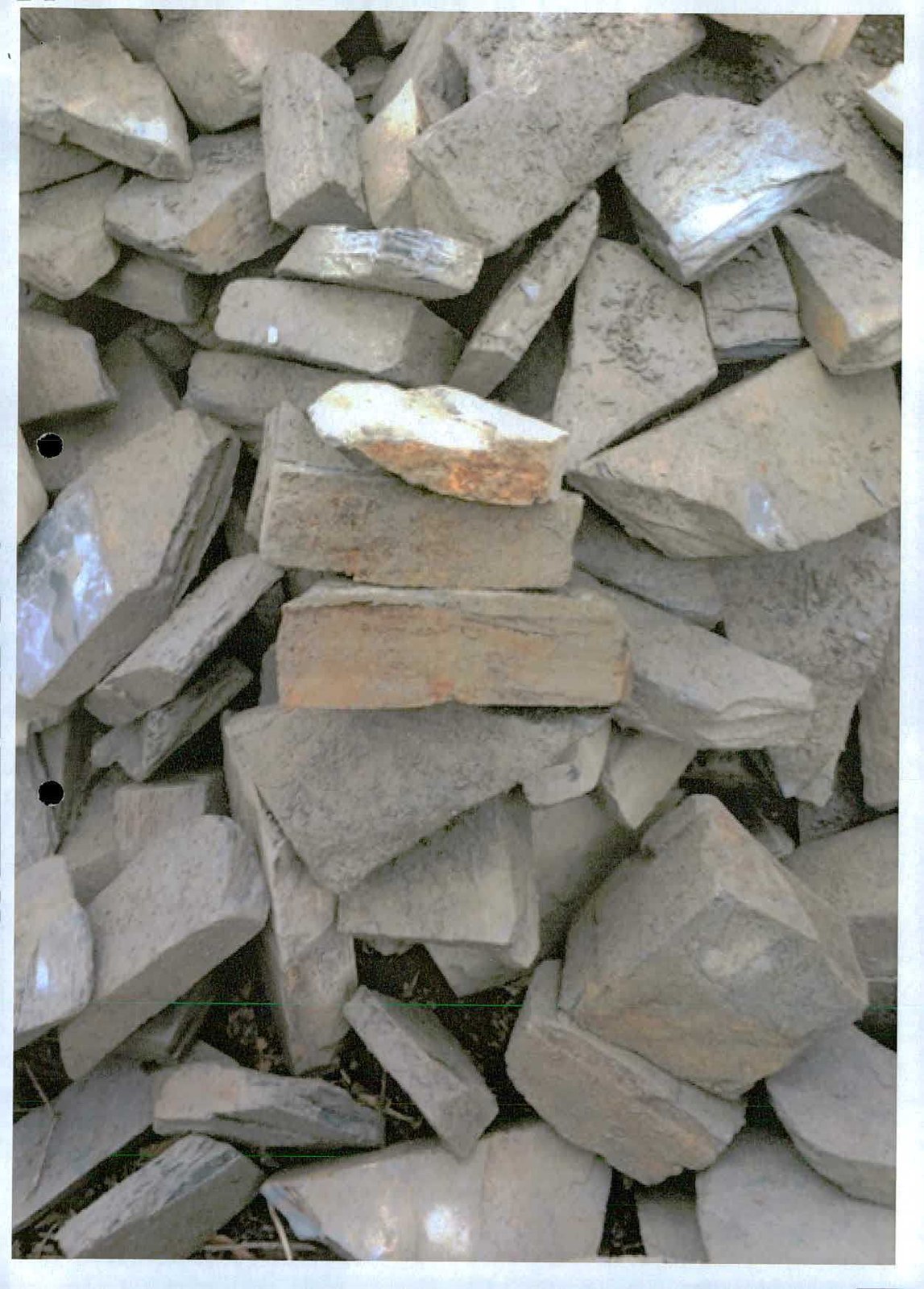 A close-up photograph showing a pile of rough, grey stones or rubble.