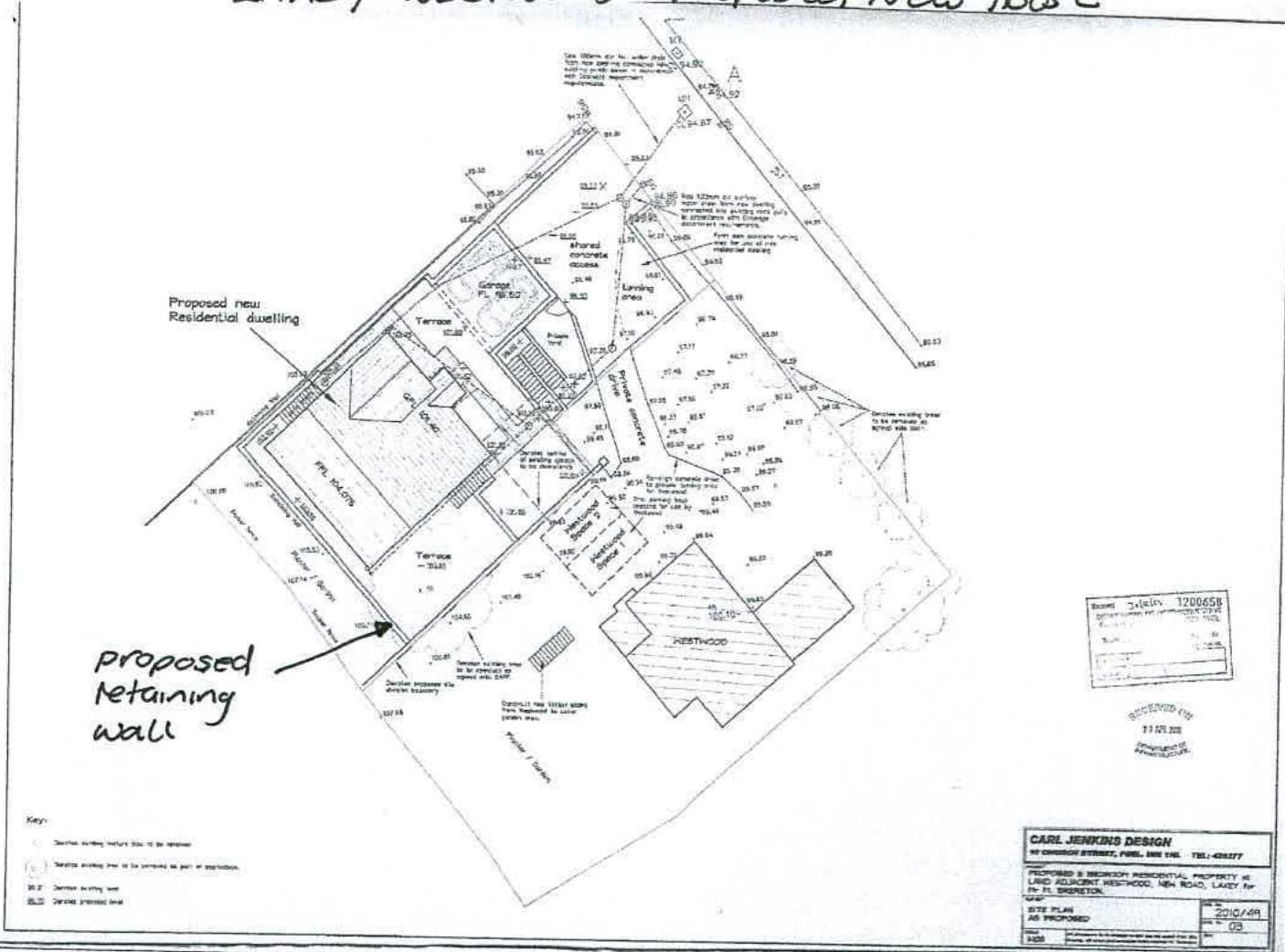 A black and white site plan showing the layout for proposed new residential dwellings, including access roads, a retaining wall, and boundary lines.