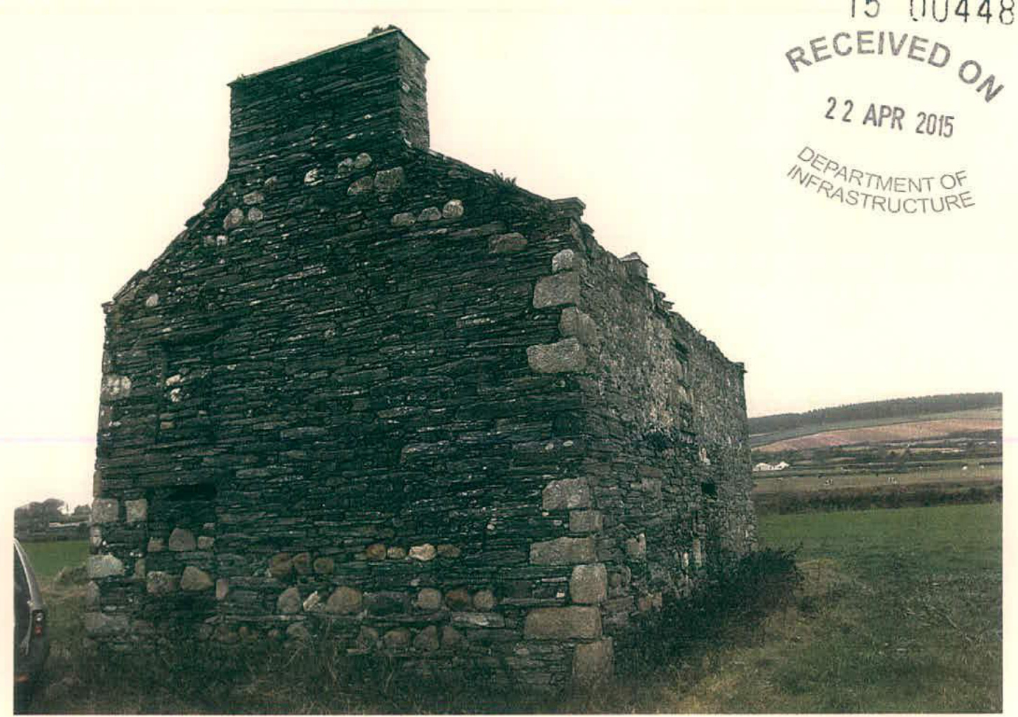 A photograph showing the exterior of a dilapidated stone tholtan (barn) with a chimney stack, situated in a rural field.