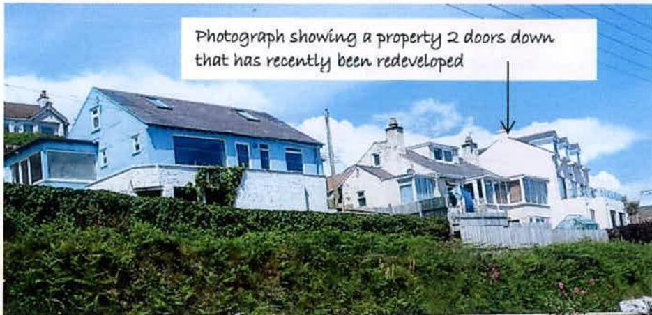 A photograph showing a row of residential houses on a hillside with a text overlay pointing to a white property that has recently been redeveloped.