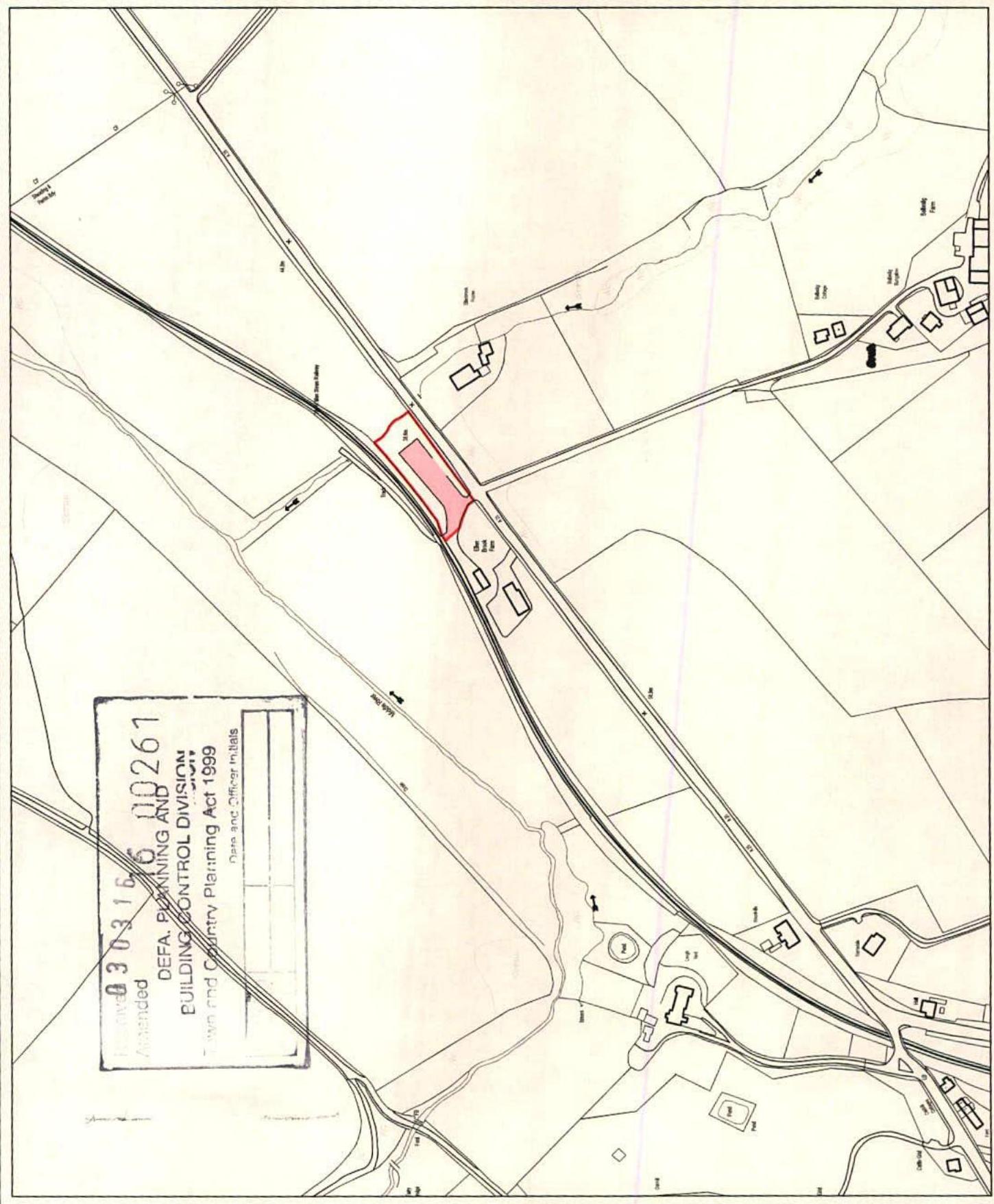 A black and white site plan showing a red highlighted plot of land near a road junction in a rural setting, stamped by the Planning and Building Control Division.