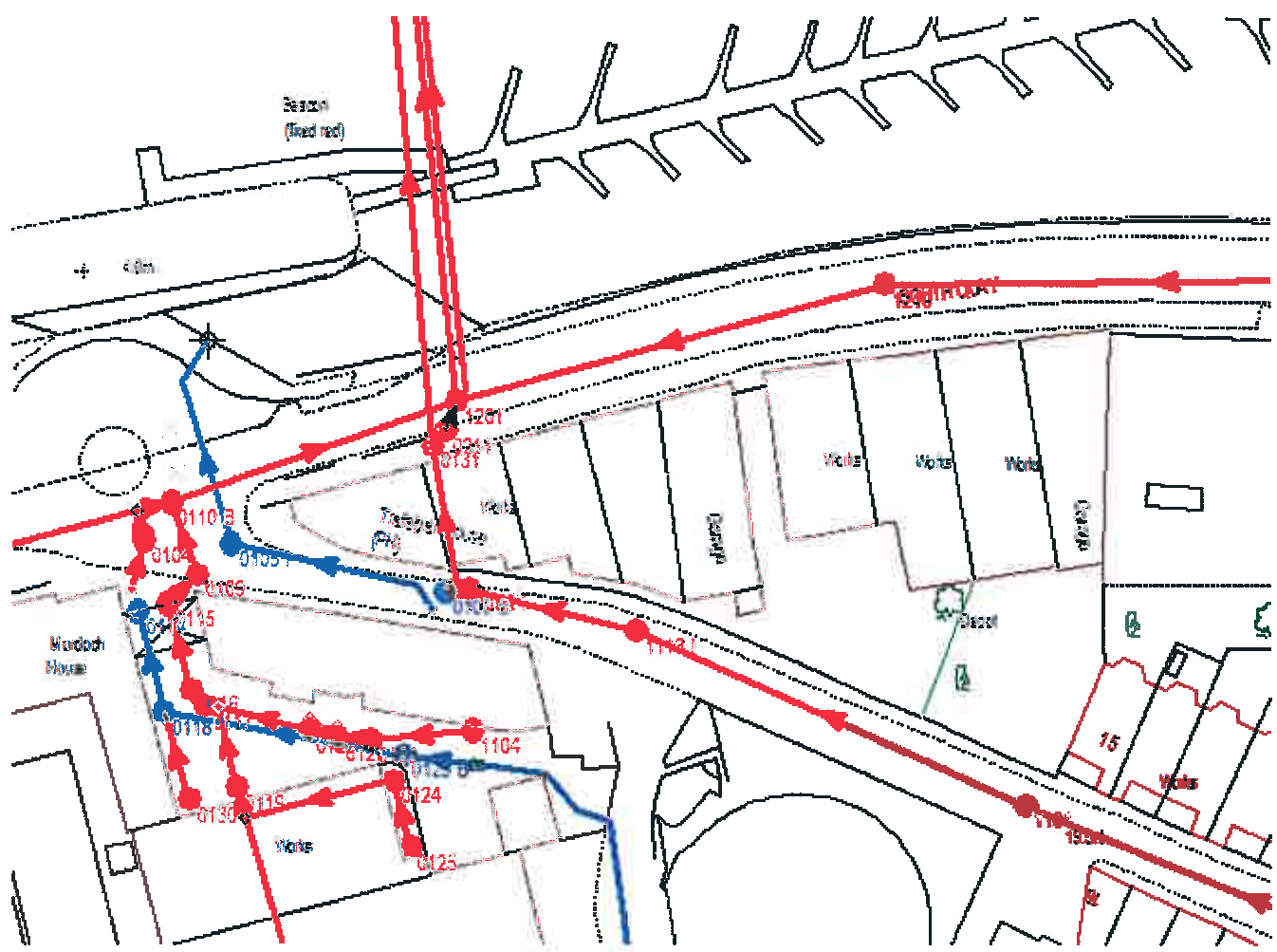 A technical site plan showing directional flow arrows in red and blue overlaid on building footprints and road layouts.
