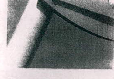 A grainy, low-resolution close-up image showing a dark angular shape, likely a roofline or corner of a structure against a lighter background.
