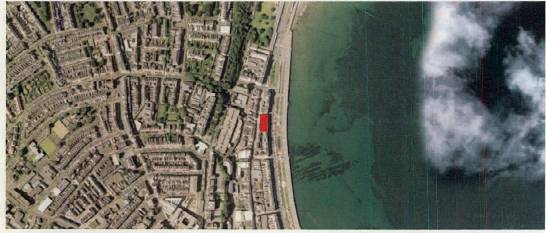 An aerial location map displaying a dense coastal urban area with a specific site highlighted in red near the waterfront.