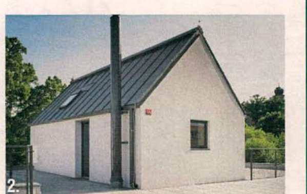 A photorealistic image or rendering of a small, white, single-story building with a pitched roof and skylight.