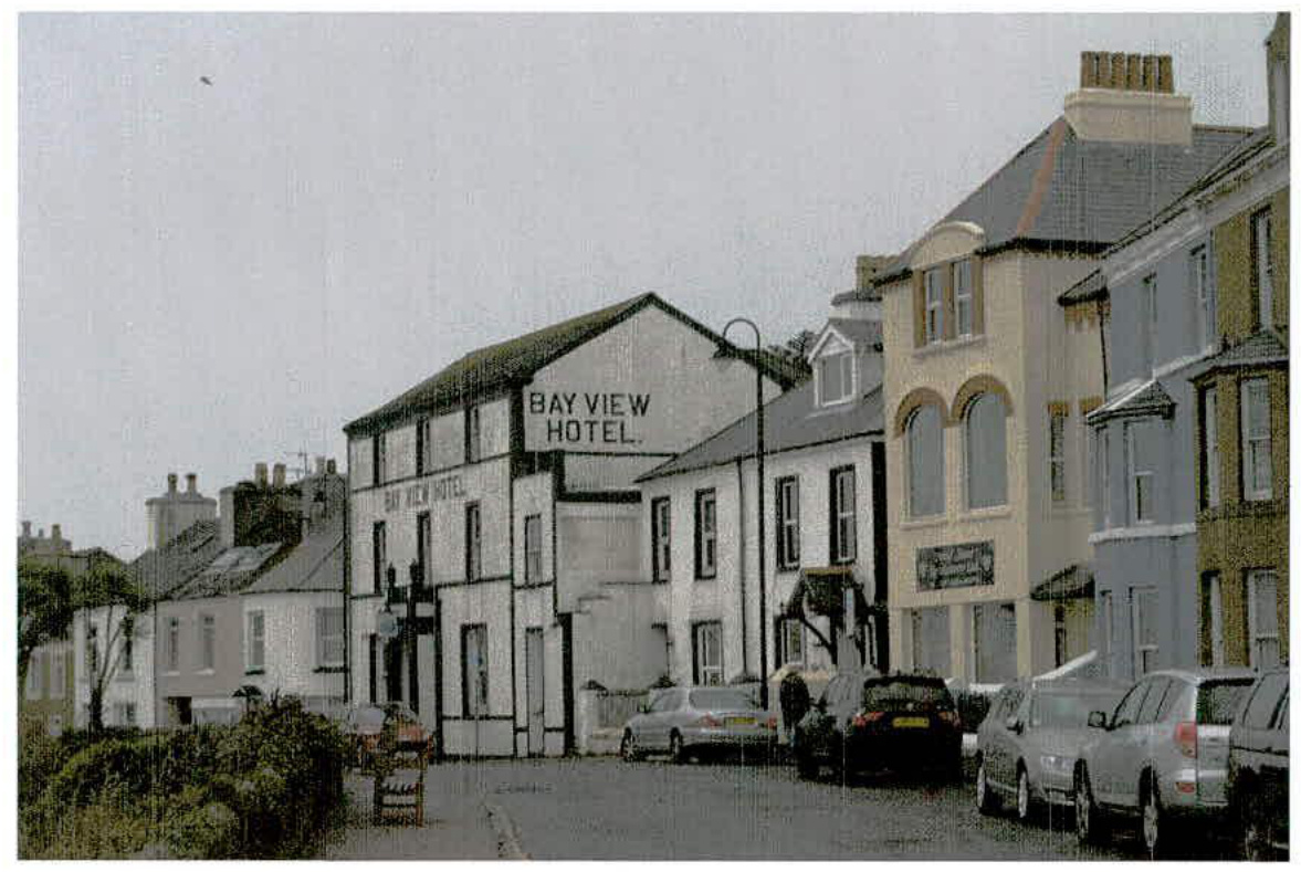 A street-level photograph showing the 'Bay View Hotel' building, which appears to be undergoing demolition or renovation, with parked cars in the foreground.