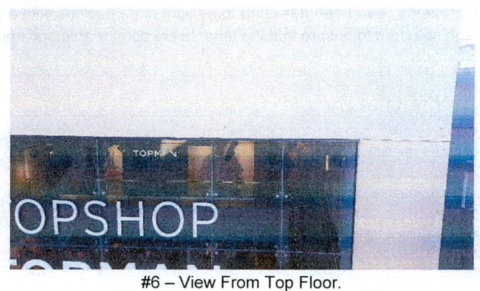 A photograph showing a view from a top floor window looking out onto a commercial building with 'TOPSHOP' signage visible on the facade.