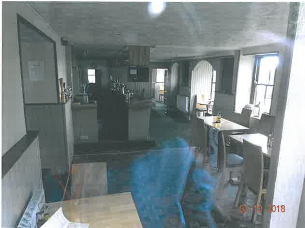 Interior photograph of a public house showing the bar area with beer taps and dining tables.