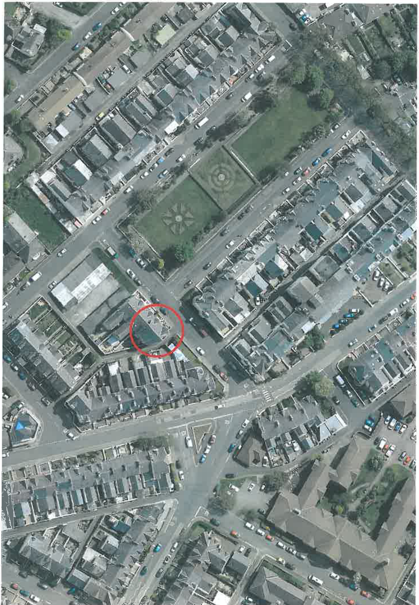 Aerial view of a residential area showing street layout and a specific property highlighted with a red circle.