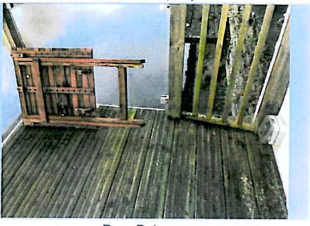 The image shows an interior room with wooden flooring and exposed timber stud framing, likely depicting the site conditions before the installation of the new doors.
