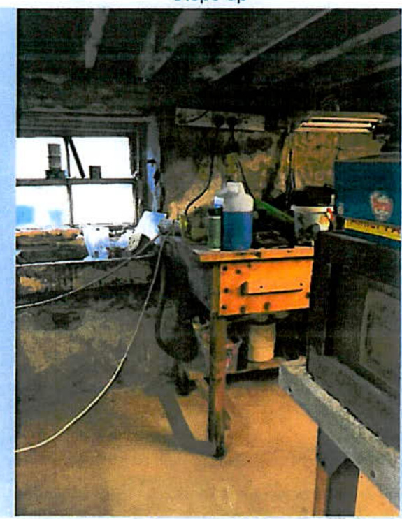 An interior photograph of a workshop or utility room showing a workbench, tools, and a window.