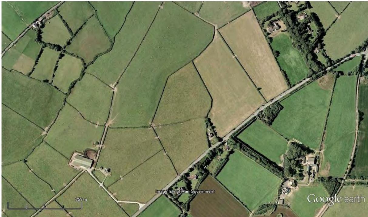 An aerial satellite view (Google Earth) showing a rural landscape with green fields, hedgerows, and a road, serving as a location map for the proposed development.