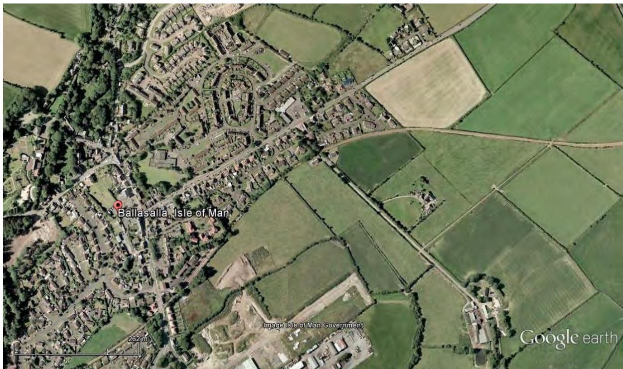Aerial satellite view showing the location of Ballasalla in the Isle of Man, displaying a mix of residential housing and agricultural fields.