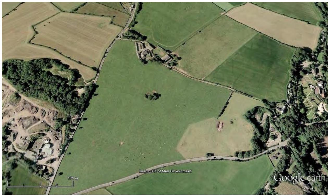 An aerial Google Earth view showing a large green field and surrounding agricultural land, serving as a site location map for the proposed development.
