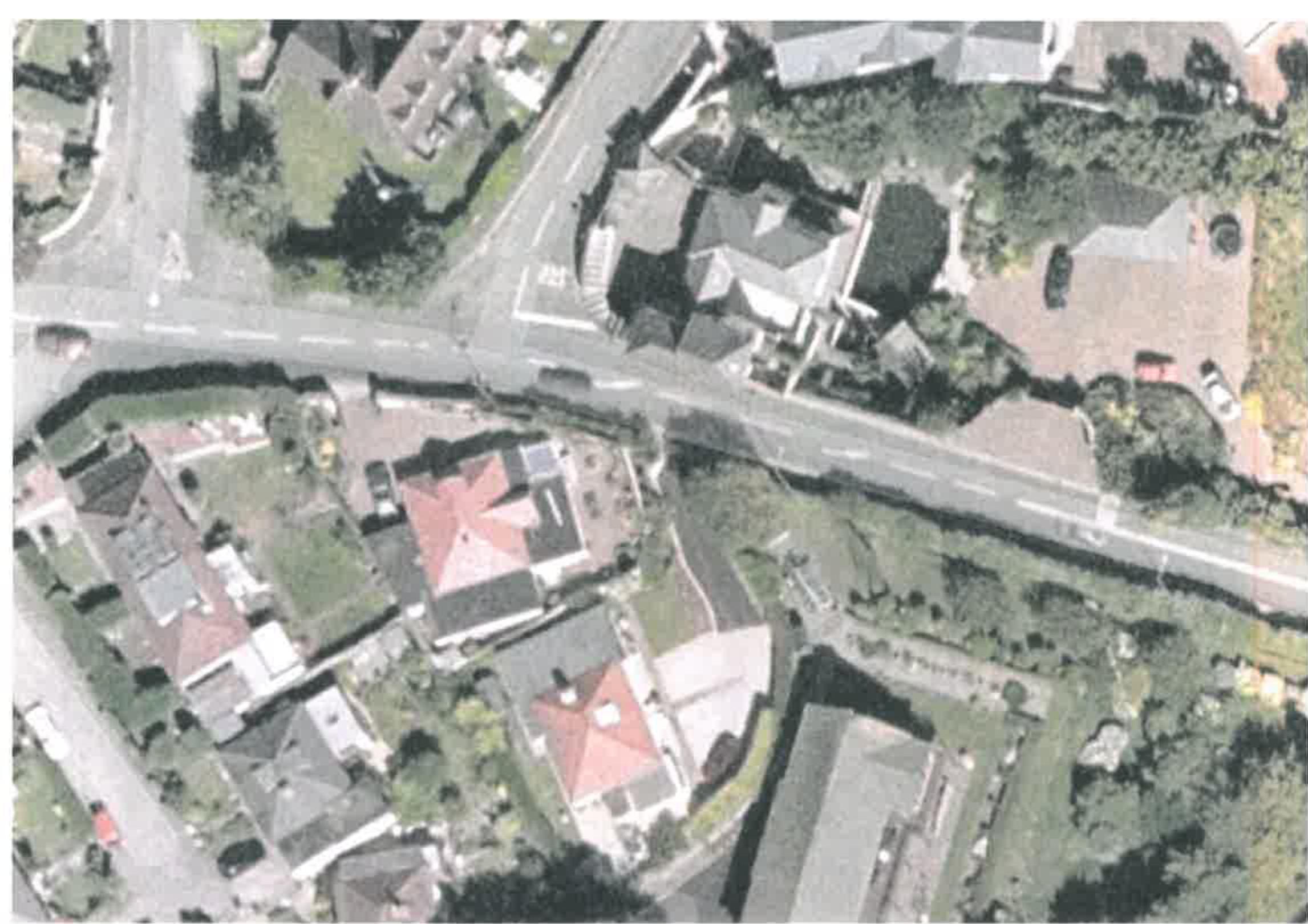 An aerial photograph showing a residential area with houses, roads, and green spaces, likely serving as a location map for the proposed development.