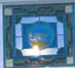 A low-resolution, close-up photograph of a window pane featuring a blue central design, likely a decorative or stained glass element.