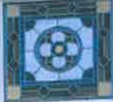 A low-resolution close-up photograph of a decorative stained glass window panel featuring a blue geometric floral design.