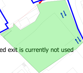 A cropped site plan showing a green highlighted area with blue boundary lines and directional arrows indicating traffic flow.
