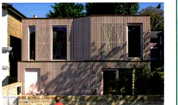 A photograph showing the exterior elevation of a modern two-story building with vertical timber cladding and large windows.