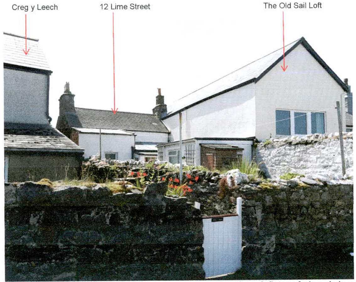 A photograph showing a street scene with three labeled properties: Creg y Leech, 12 Lime Street, and The Old Sail Loft, separated by stone walls.