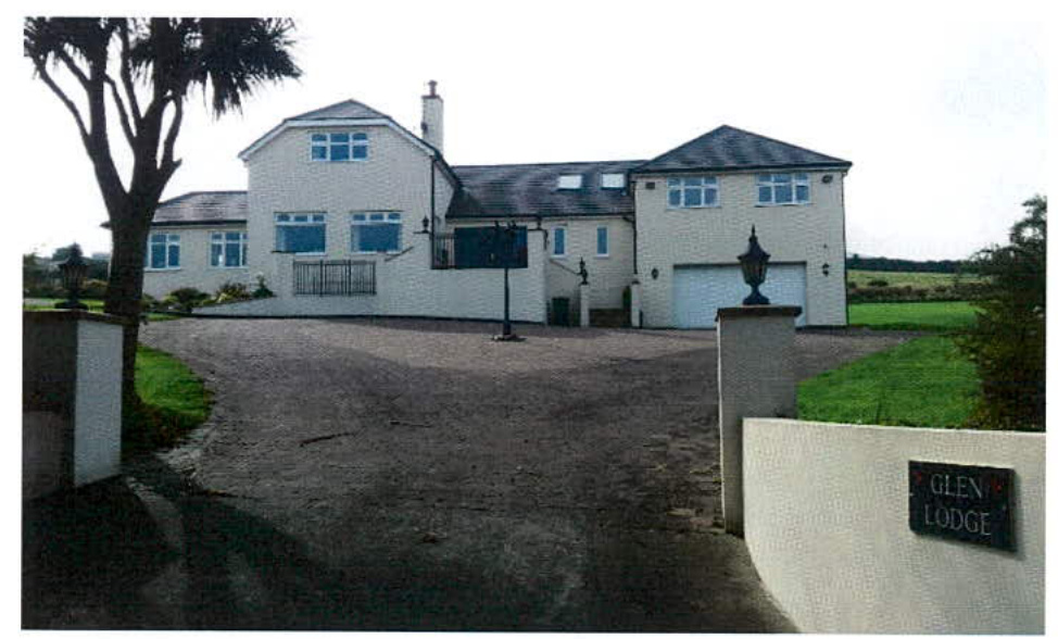 A photograph of a large white detached house named Glen Lodge featuring a gravel driveway and garage.