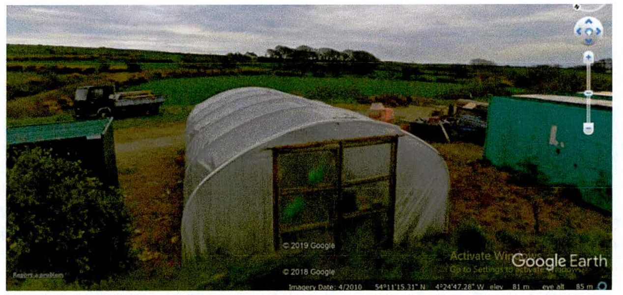 A Google Earth screenshot showing an aerial perspective of a rural site with a polytunnel and storage containers.