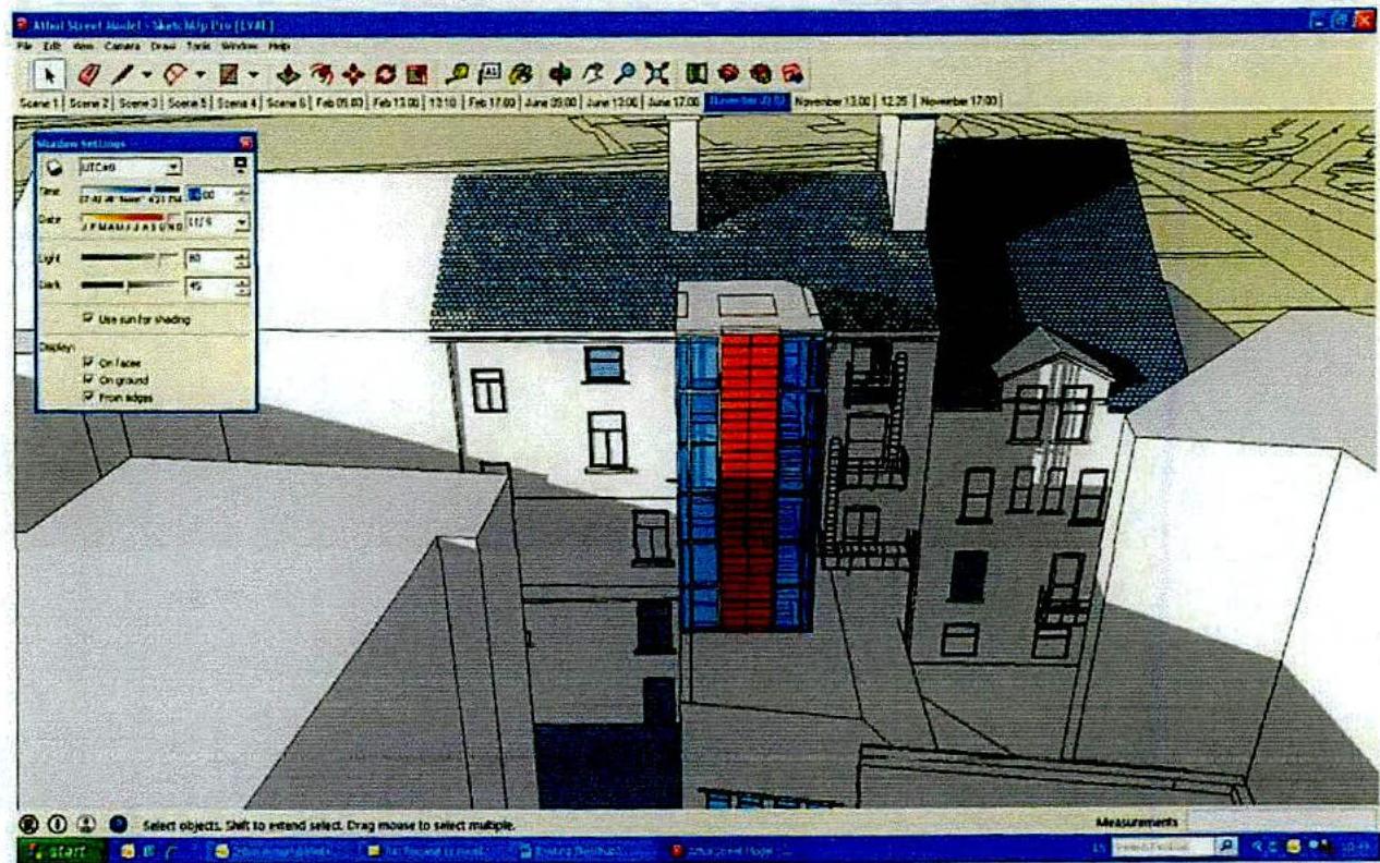 A screenshot of 3D modeling software displaying a street scene with a proposed red and blue building element against a topographical map background.